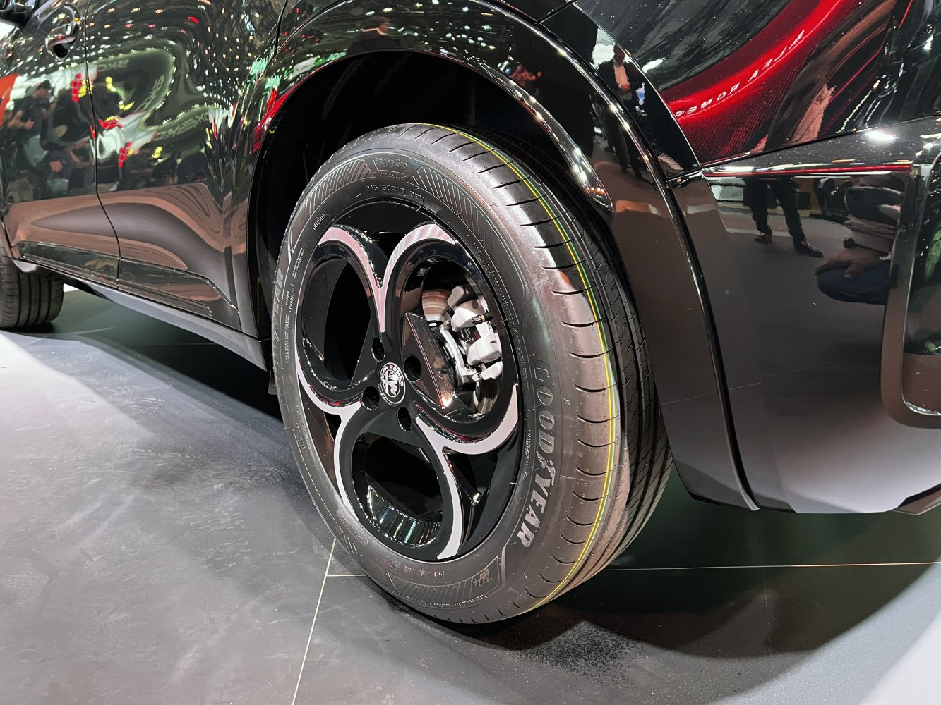 Close-up of a 3-hole alloy wheel with Goodyear tire on a black vehicle