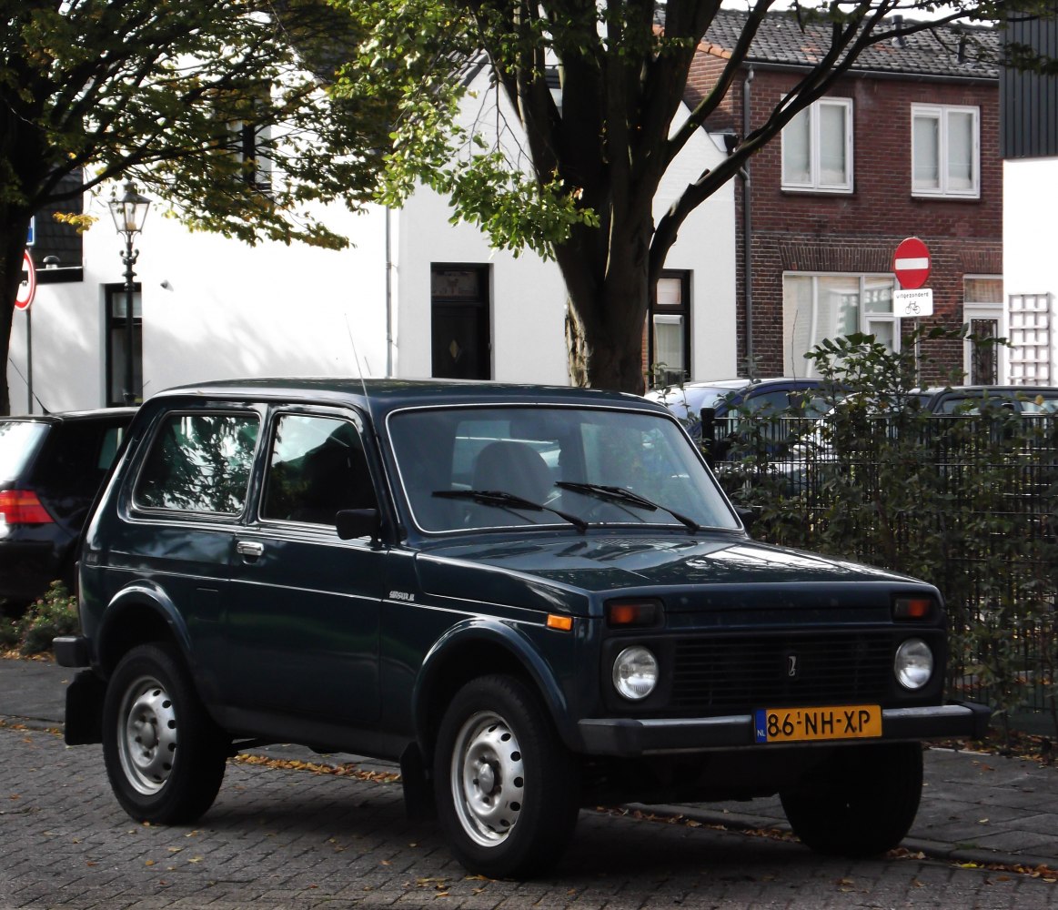 Front-side view of 3-door compact SUV with round headlights and steel wheels