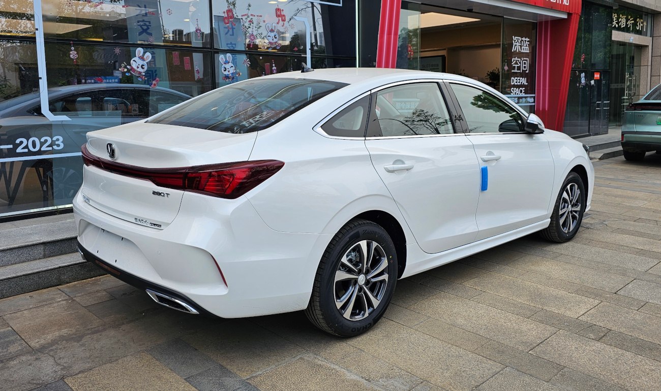Rear and side view of a white modern sedan with distinctive taillights and alloy wheels