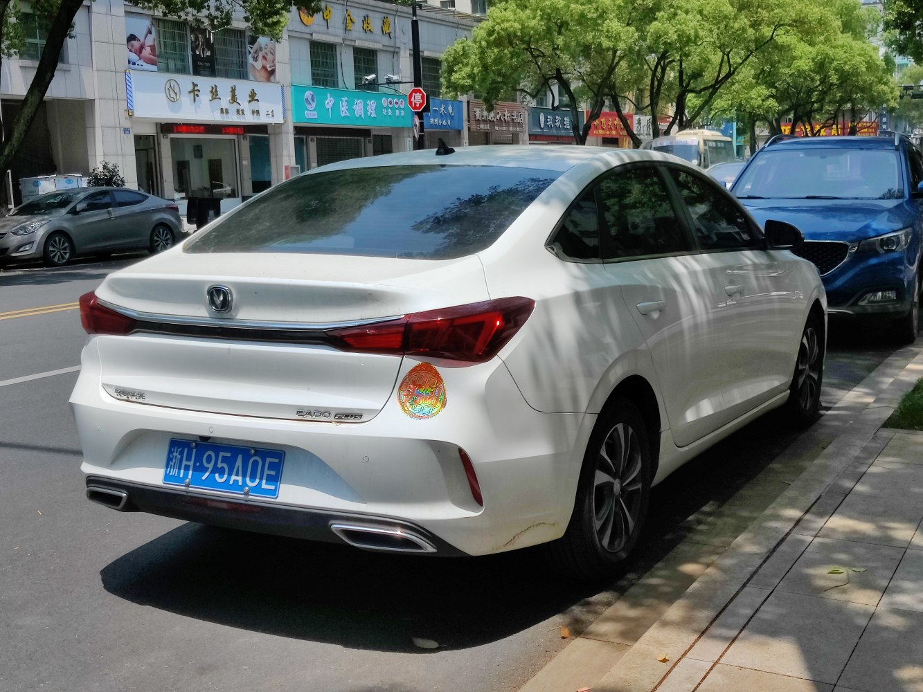 Rear view of white sedan with sharp tail lights and dual exhausts