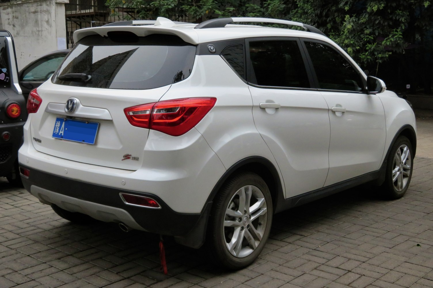 Rear and side view with roof spoiler and alloy wheels