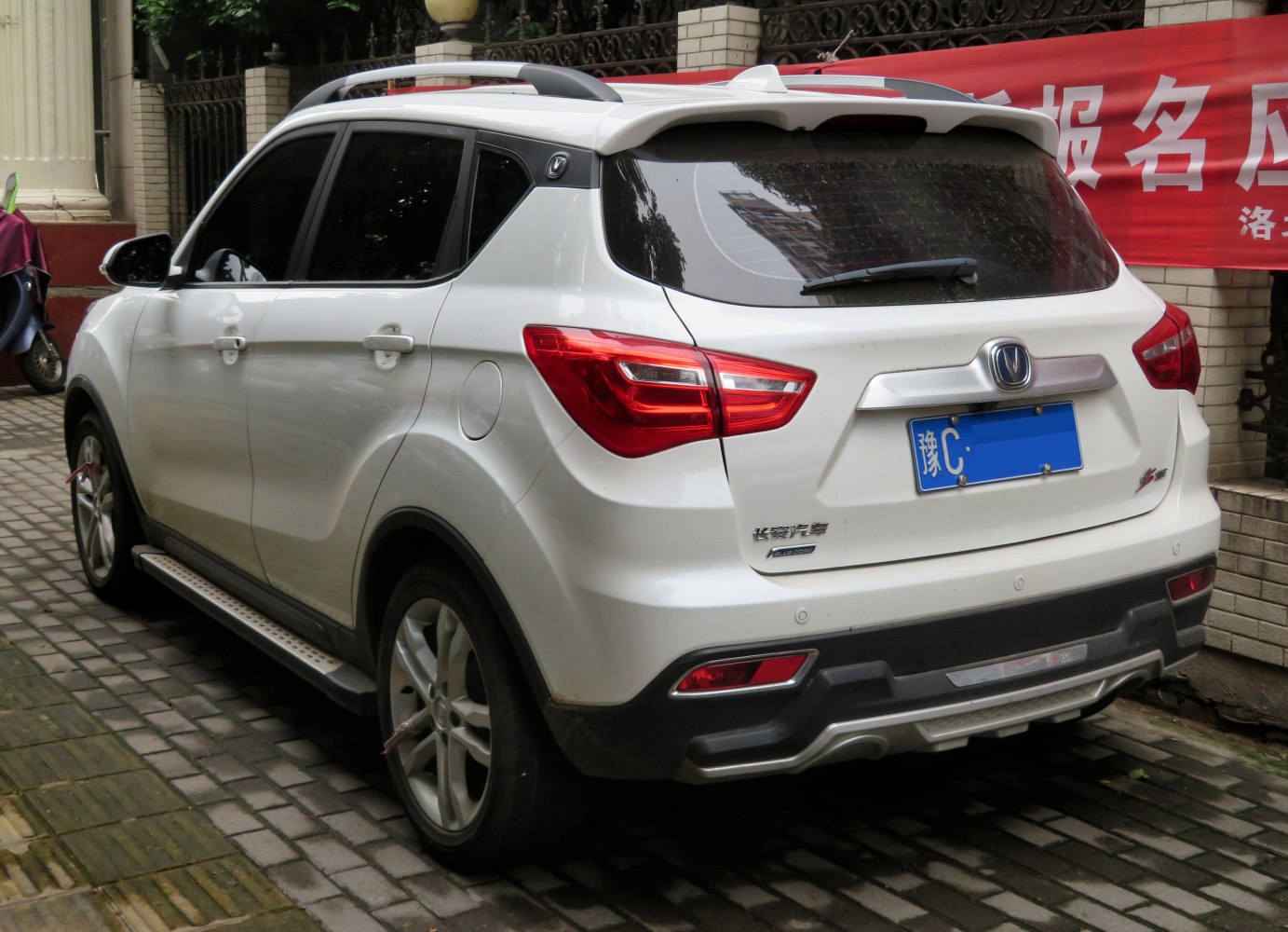 Rear and side view of white SUV with roof rails and distinct taillights