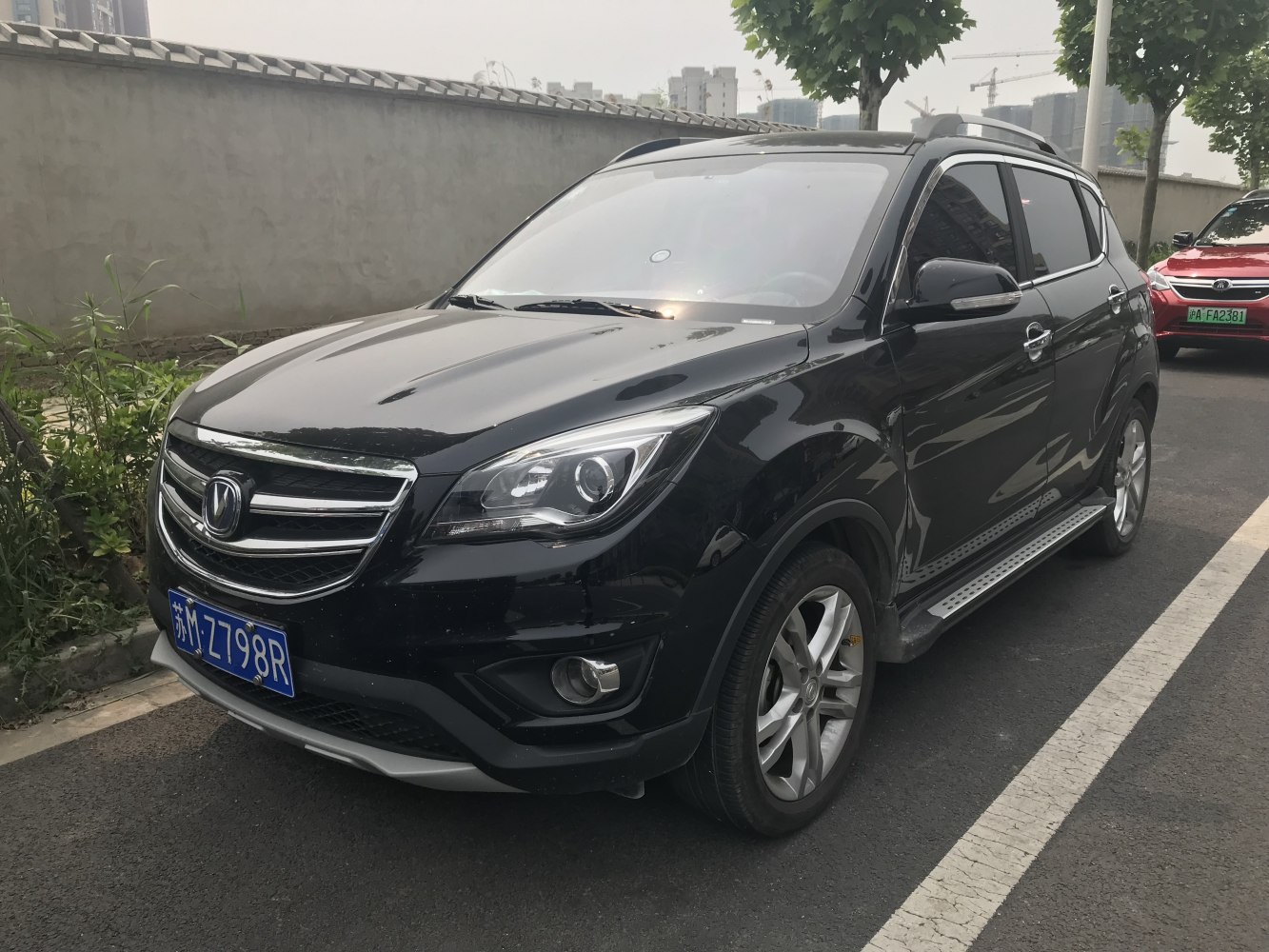 Front-side view with headlights, grille, alloy wheels, and side step