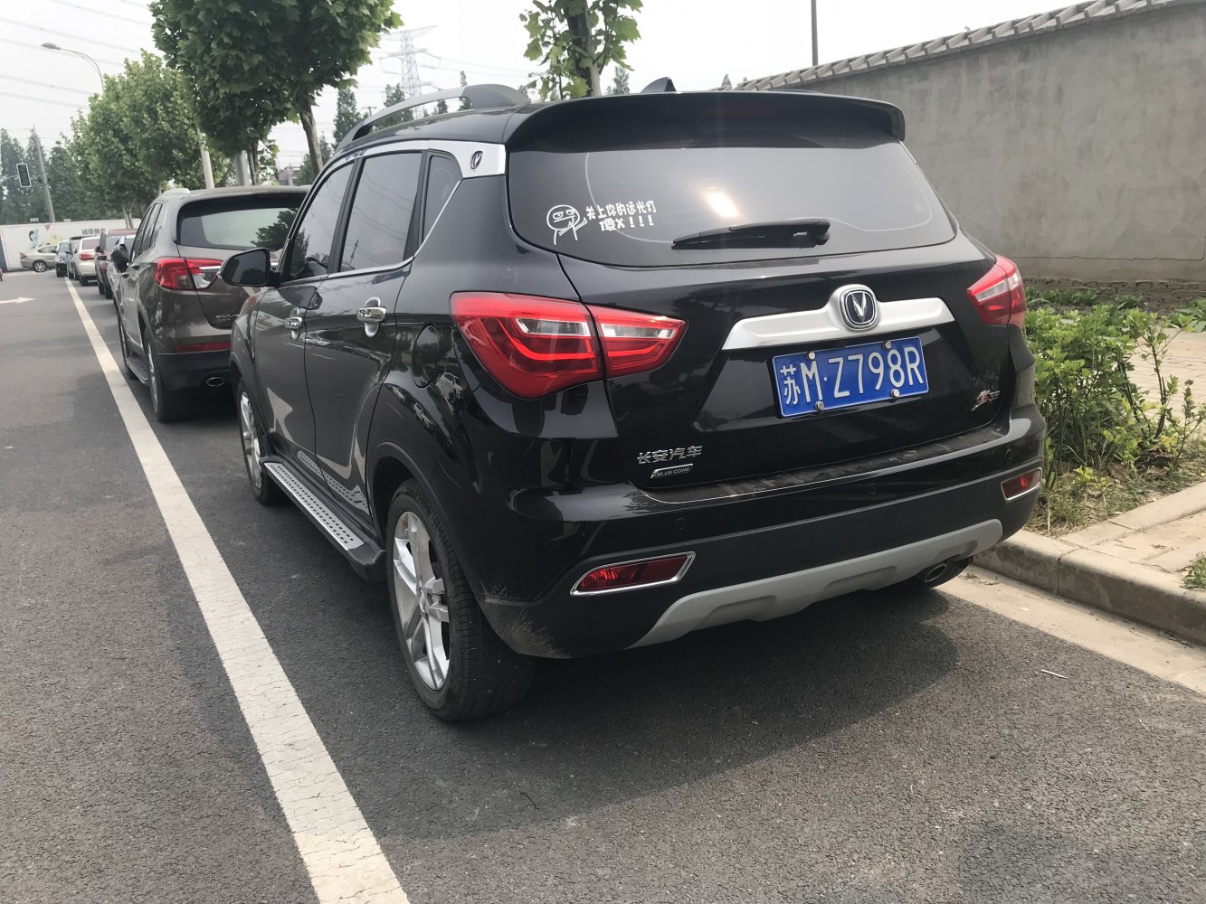 Rear view with taillights, rear spoiler, and roof rails of a compact SUV