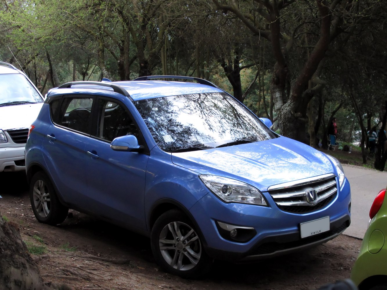 Blue compact SUV front with grille, headlights, and roof rails