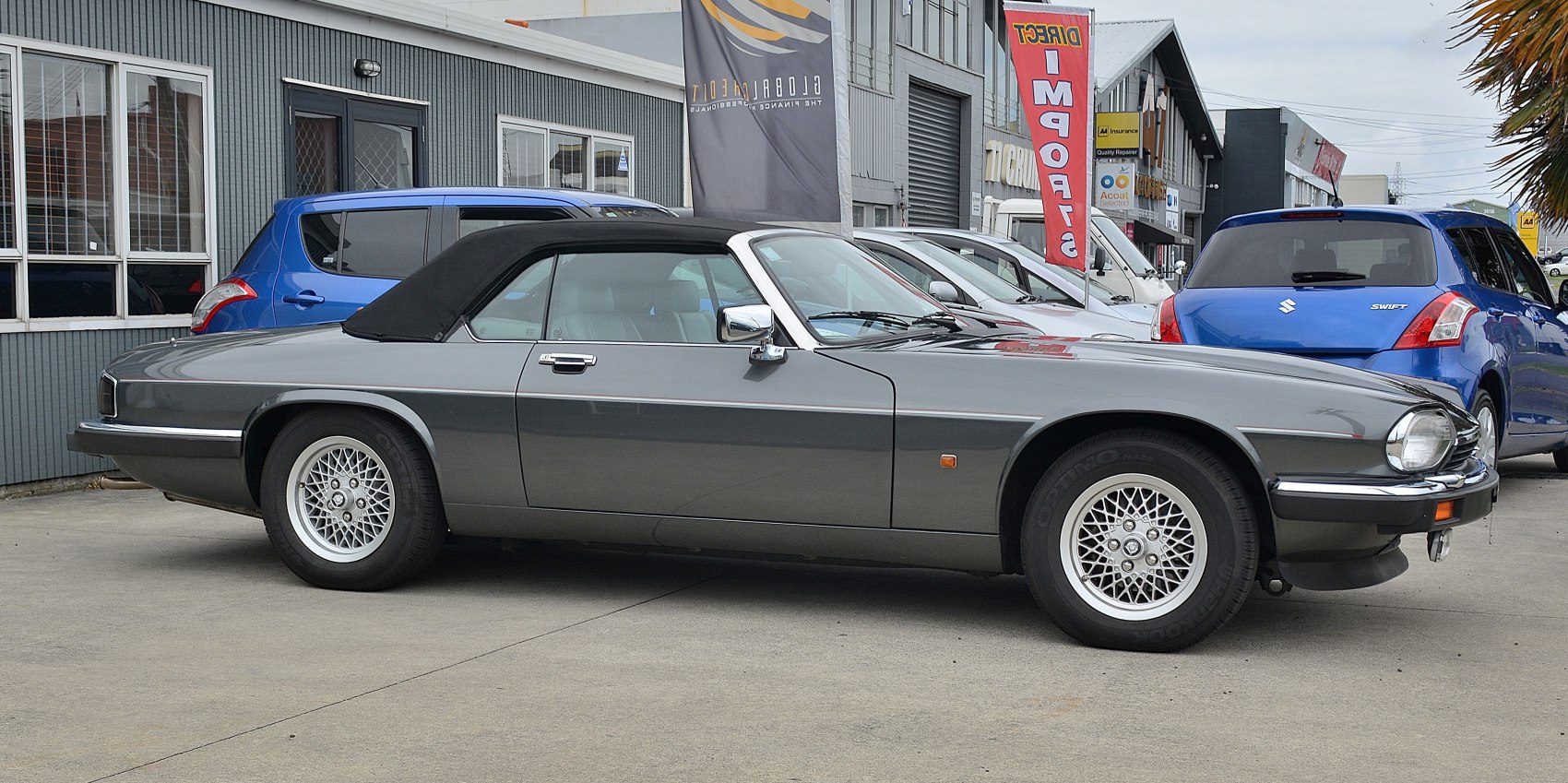 Convertible with black soft top and wire-spoke wheels side profile