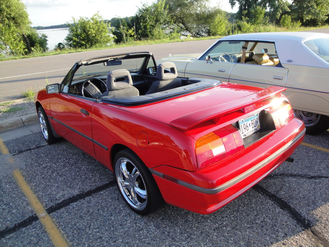 Red convertible sports car rear view with spoiler and chrome wheels