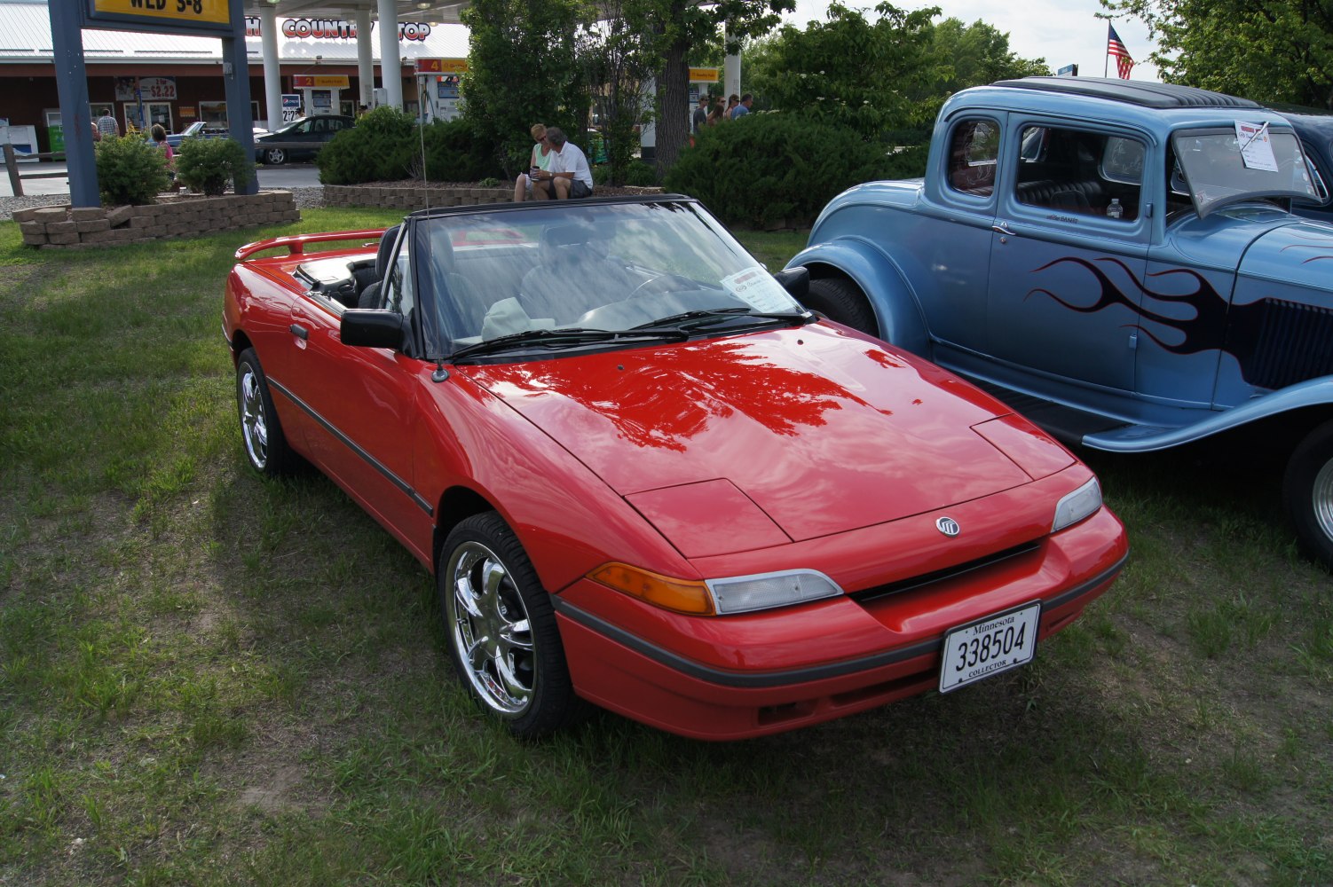 Red convertible sports coupe with pop-up headlights and sleek design.