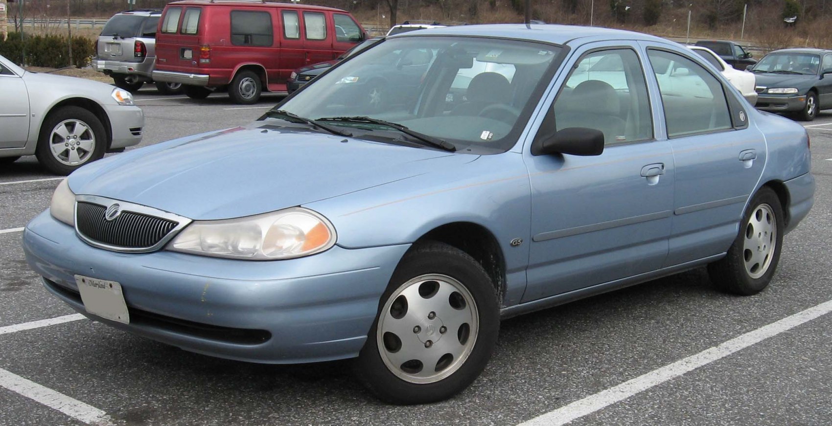Blue four-door sedan with alloy wheels, front and side angle