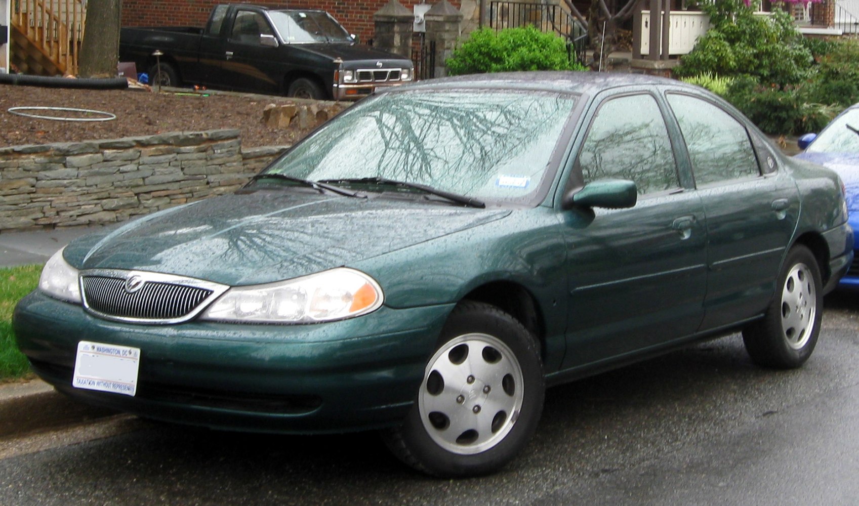 Front and side view of a green sedan with distinct grille and wheel design
