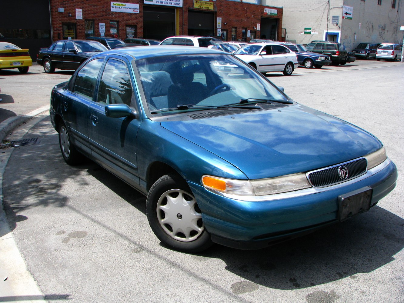 Blue four-door sedan front side view with distinctive grille and headlights