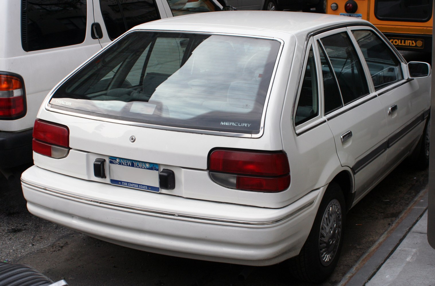 Rear view of a 5-door hatchback with rectangular tail lights and large rear window.