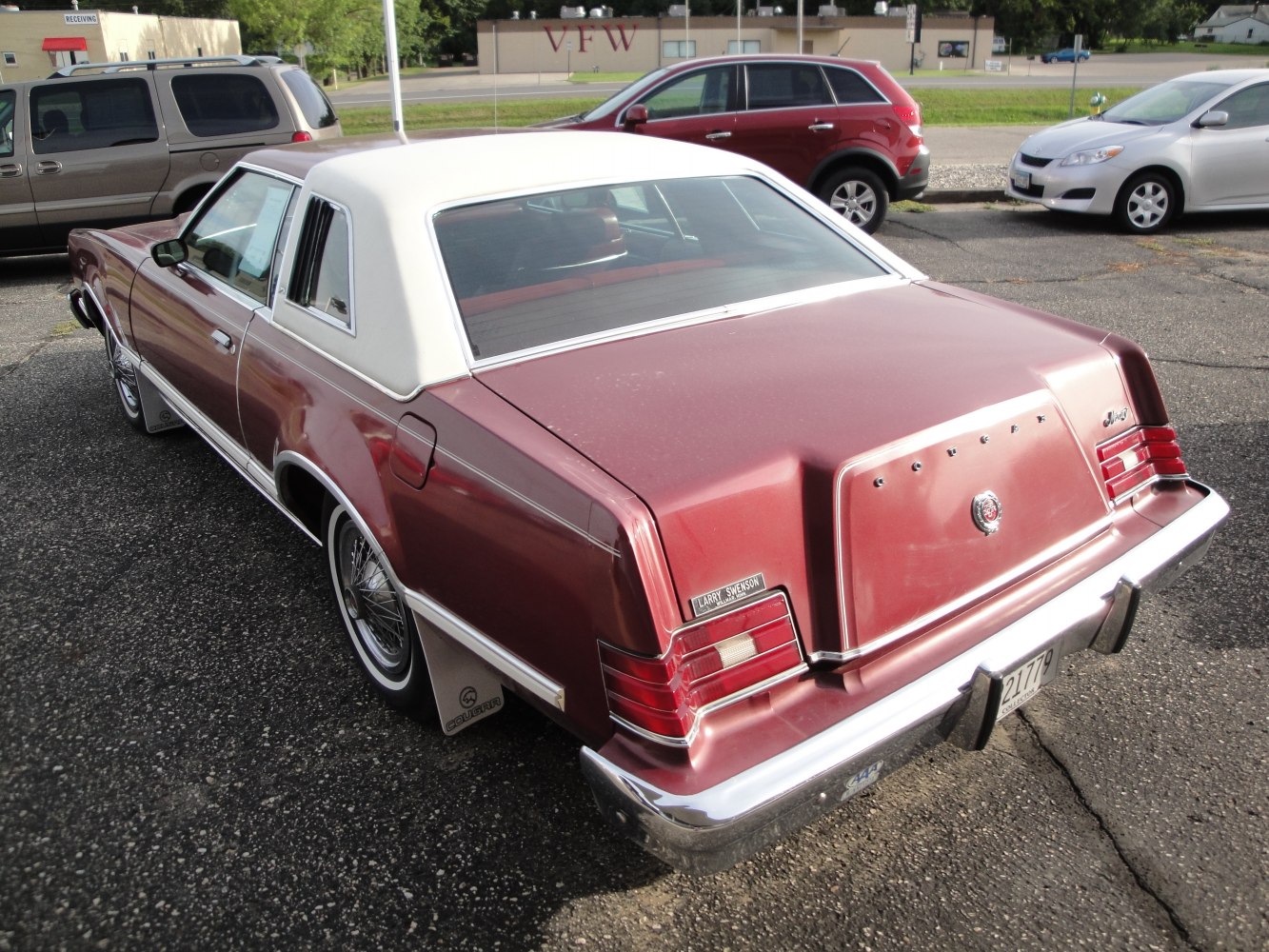 Rear view of vintage car with white vinyl roof and detailed tail lights