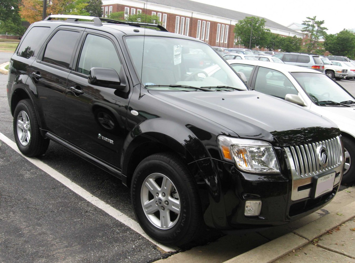 Front side view of a black SUV with chrome grille and alloy wheels