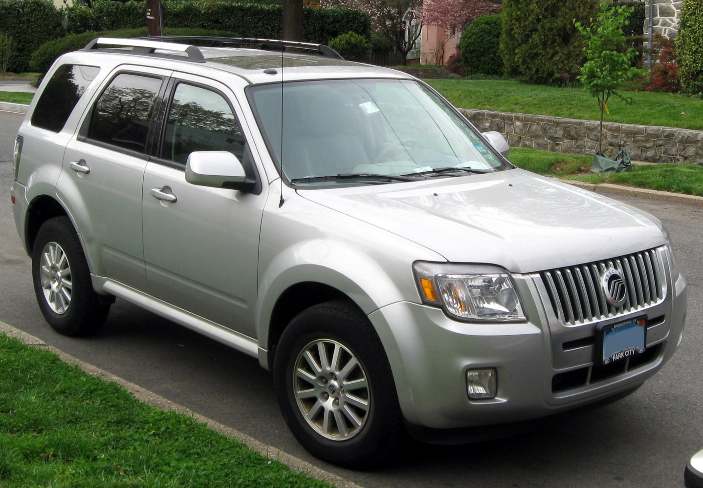 Front side view of a silver mid-size SUV with roof rails and alloy wheels