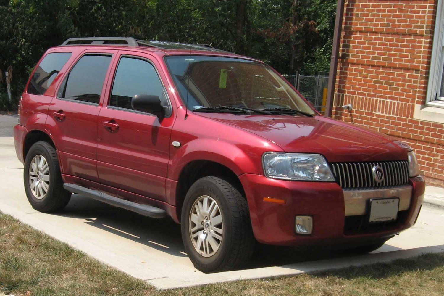 Red mid-sized SUV front and side view with roof rails and side steps
