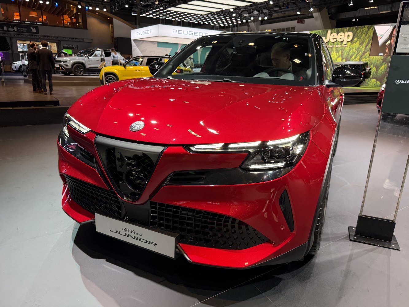 Front view of red vehicle with LED headlights and iconic grille.