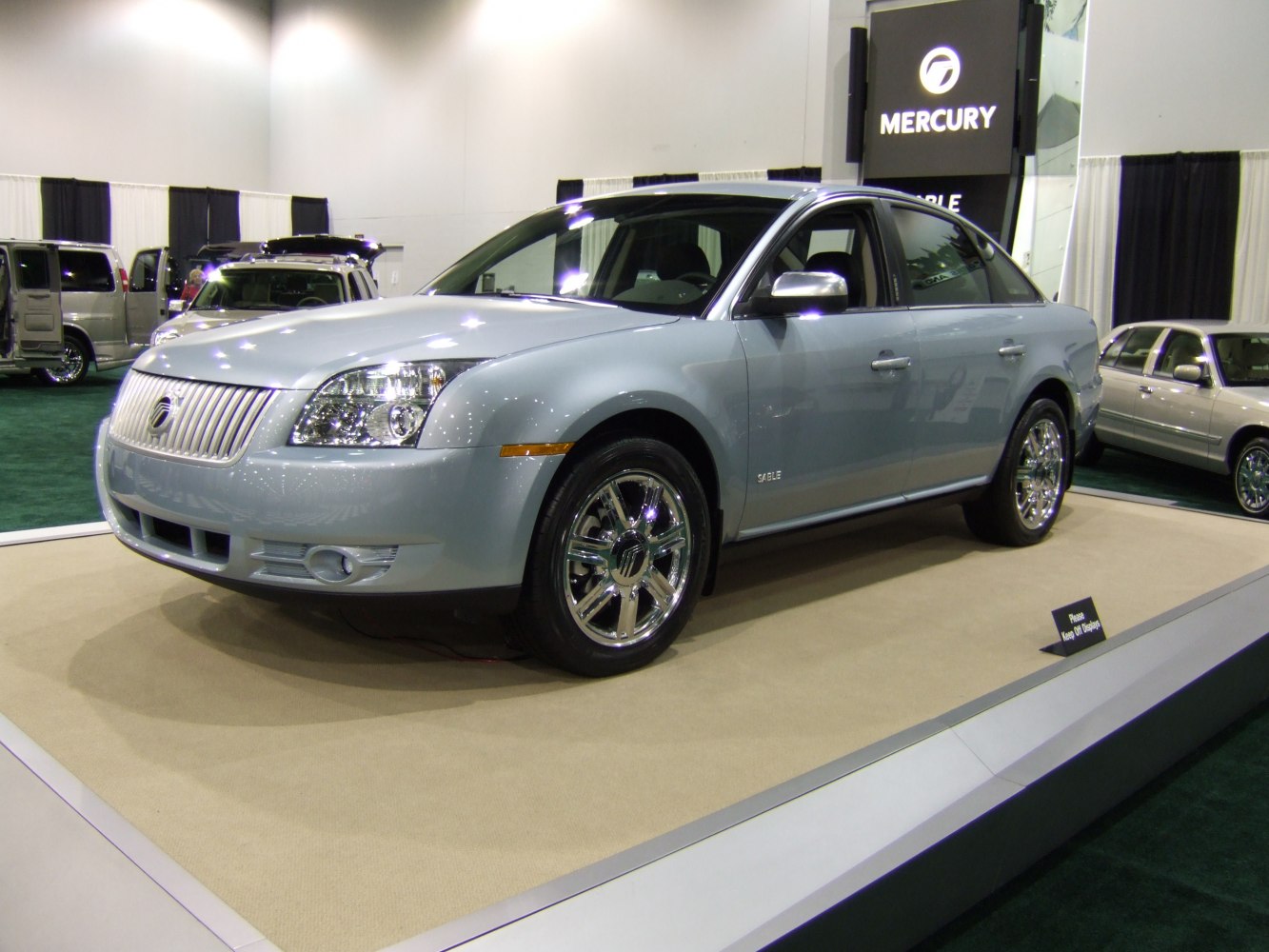 Front side view of a sedan with chrome wheels and distinctive grille