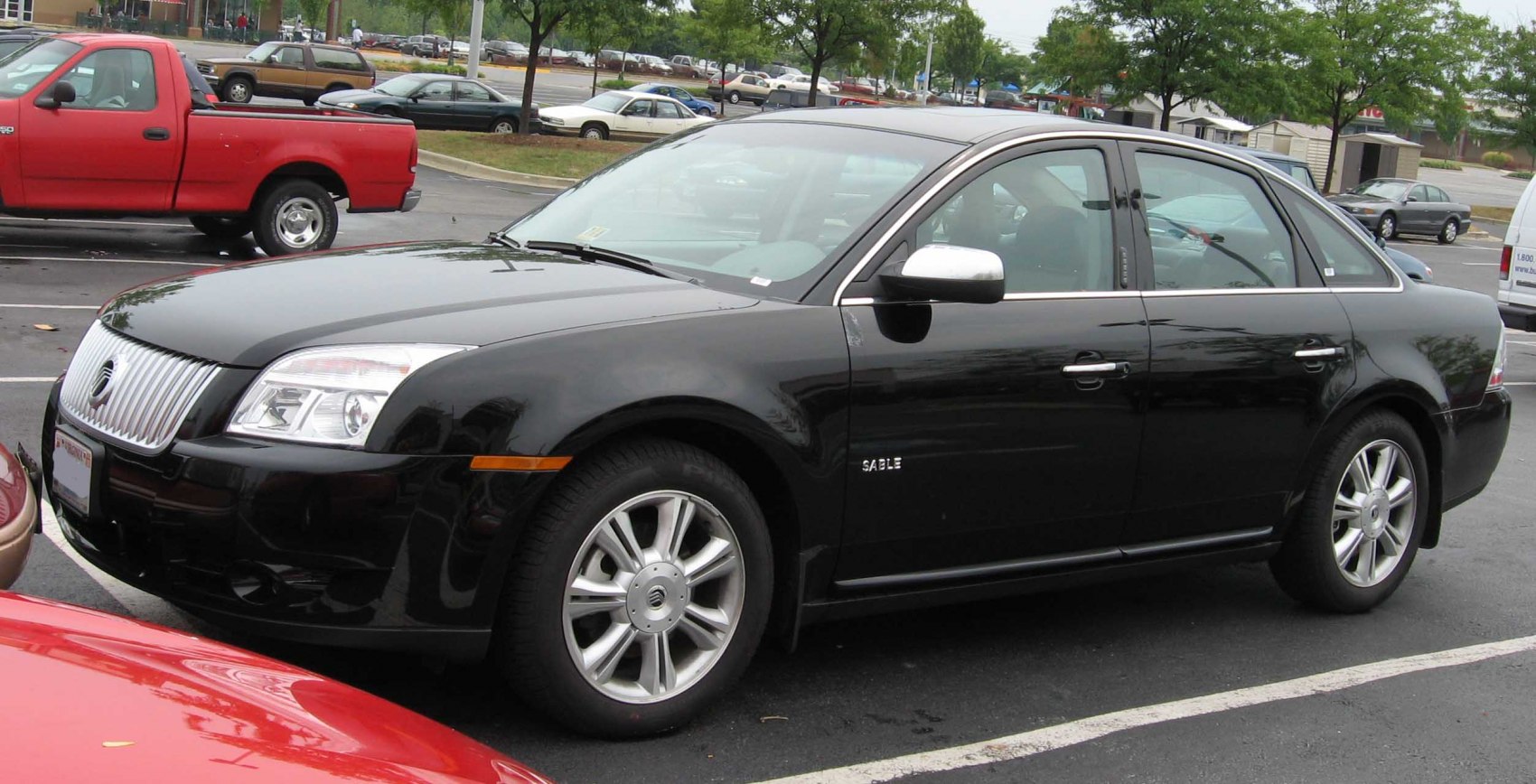 Black mid-size sedan with front grille and alloy wheels