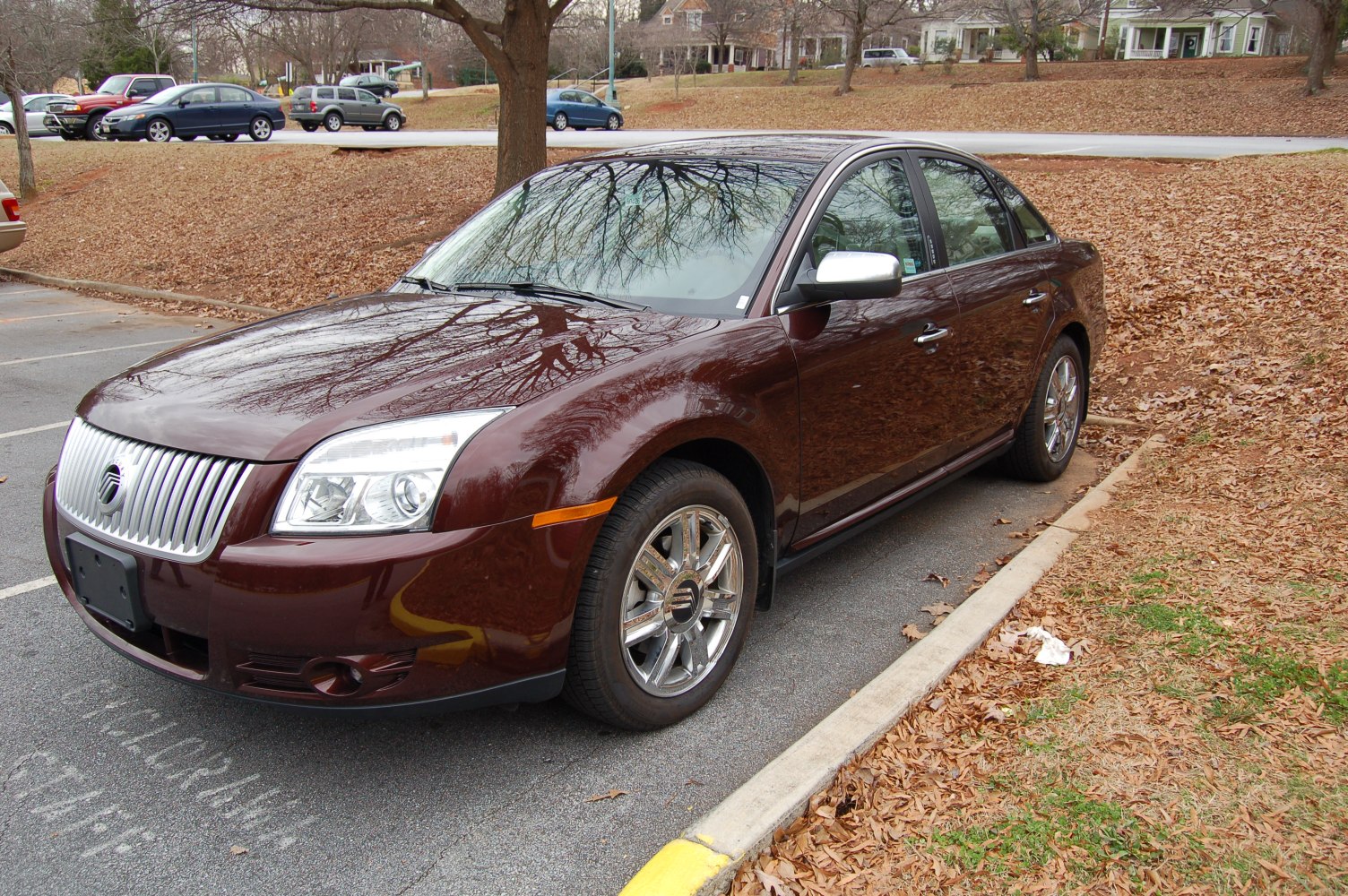 Front side view of sedan with chrome grille and alloy wheels