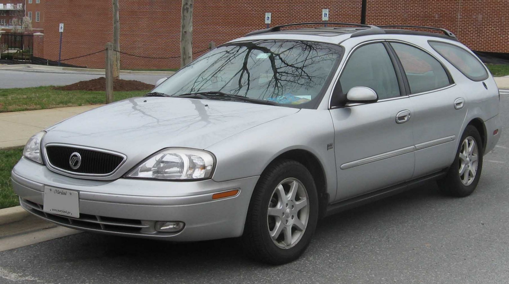 Front side view of a silver station wagon with alloy wheels and roof rails