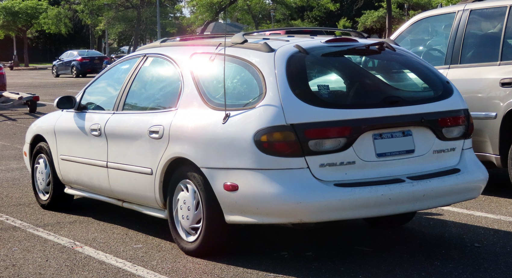 White station wagon with rounded rear windows and rear side view
