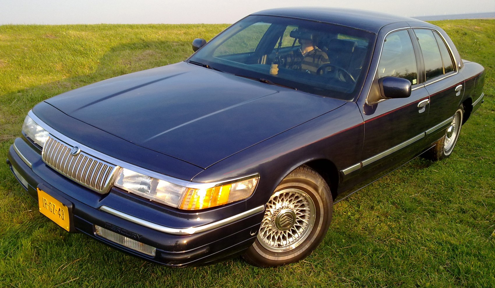 Classic chrome grille and wire-spoke wheels on early 90s sedan