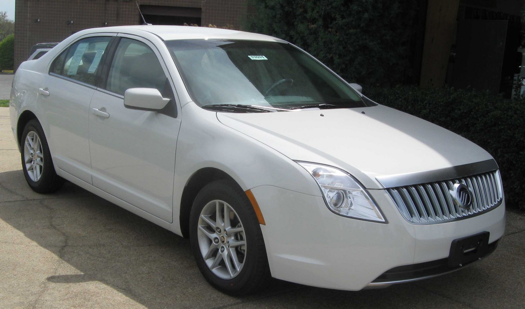 White sedan with vertical chrome grille and alloy wheels