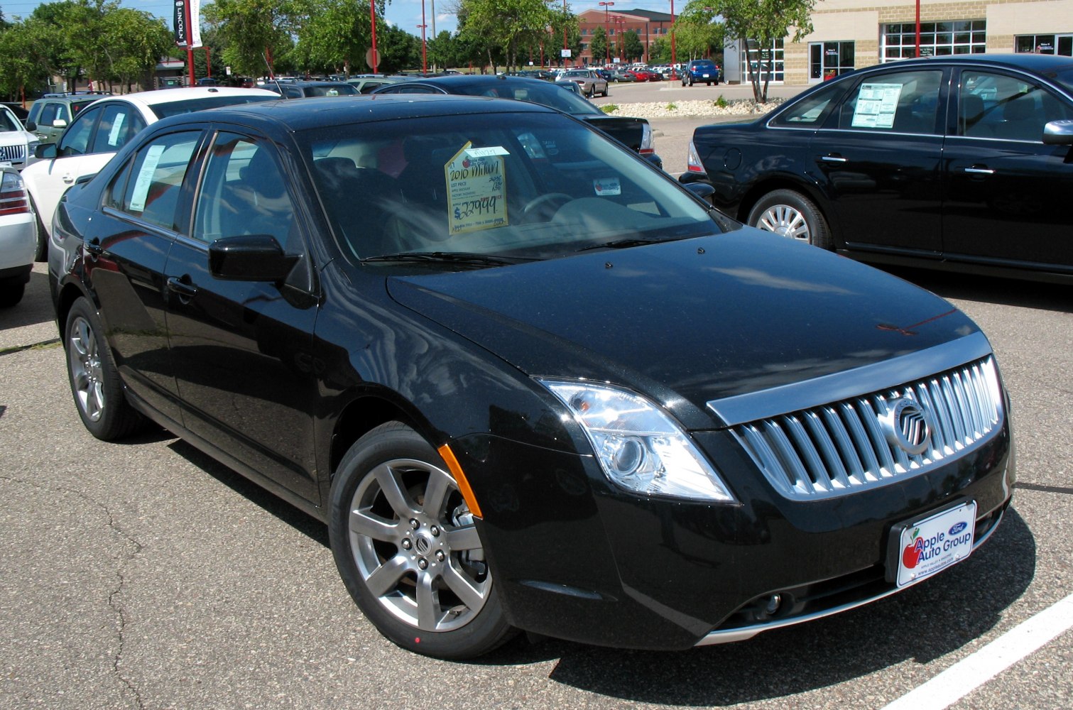 Black sedan with chrome vertical slat grille and alloy wheels