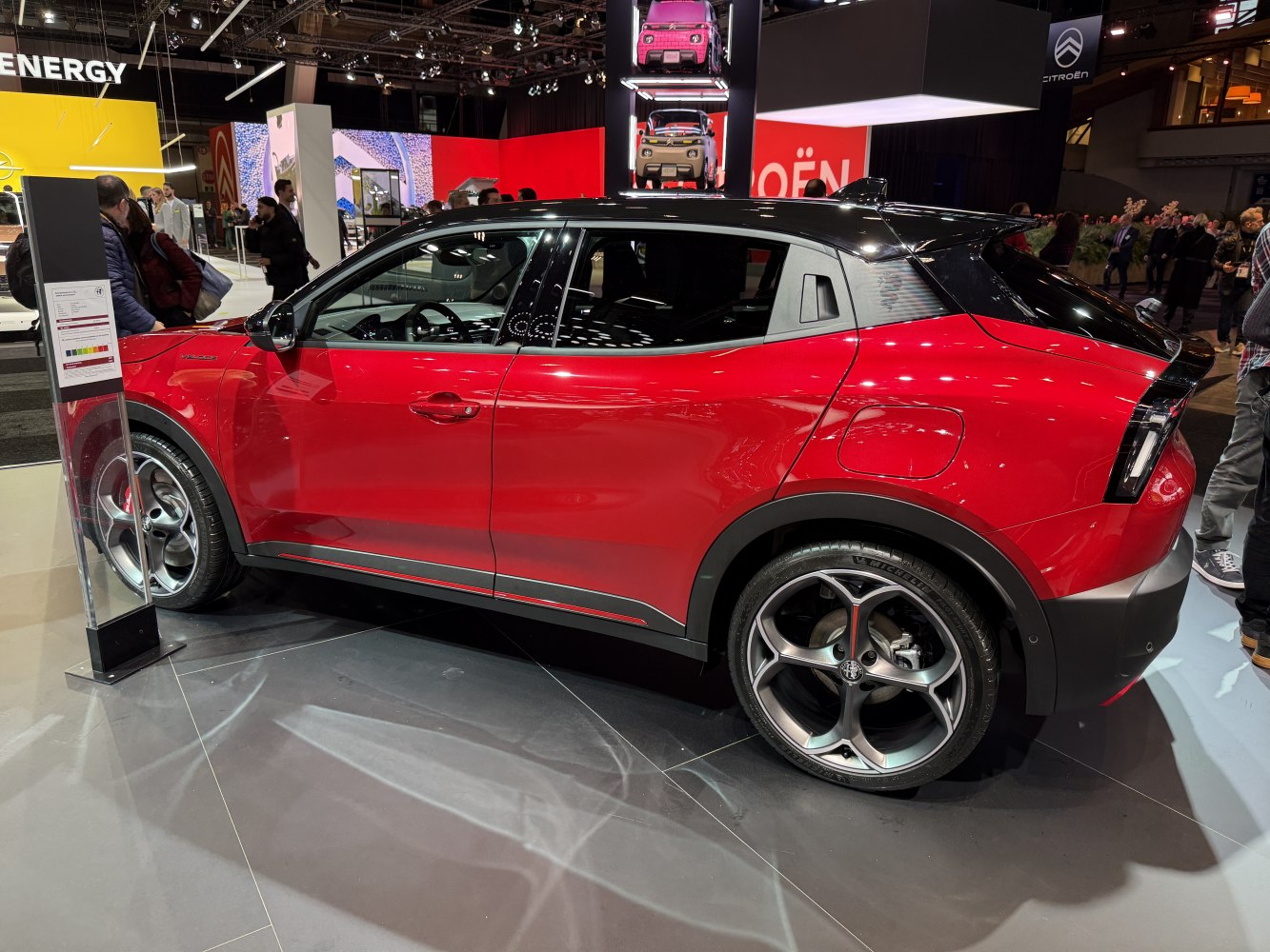 Side profile of red compact SUV with black roof and alloy wheels