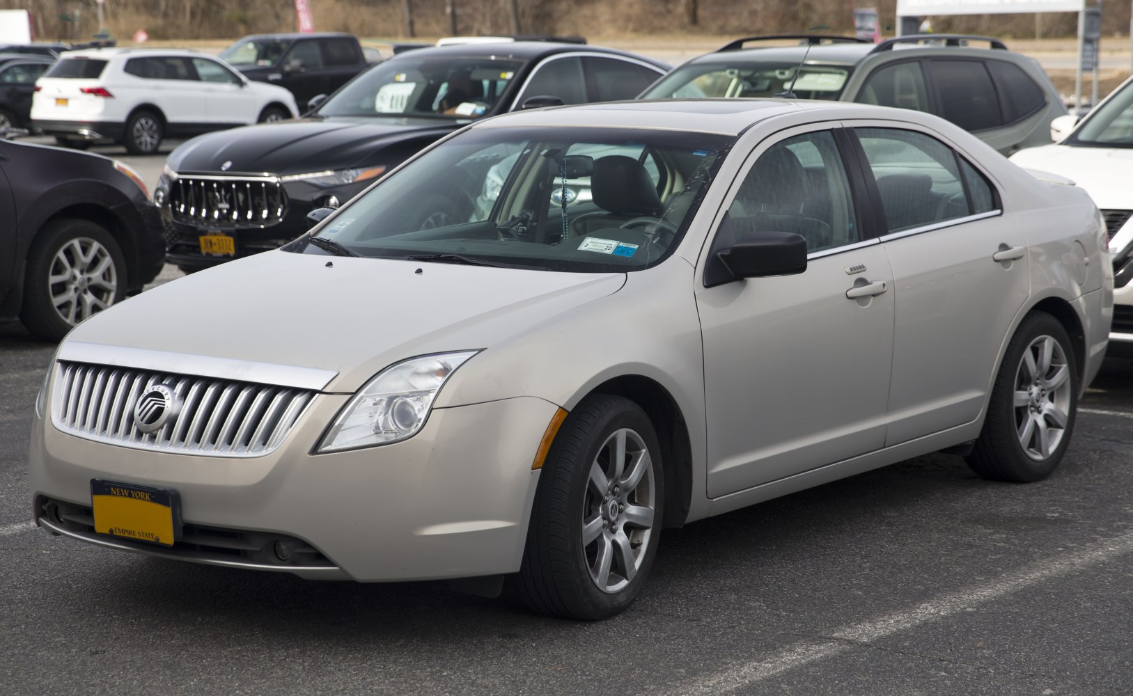 Front and side view of midsize sedan with vertical grille and alloy wheels