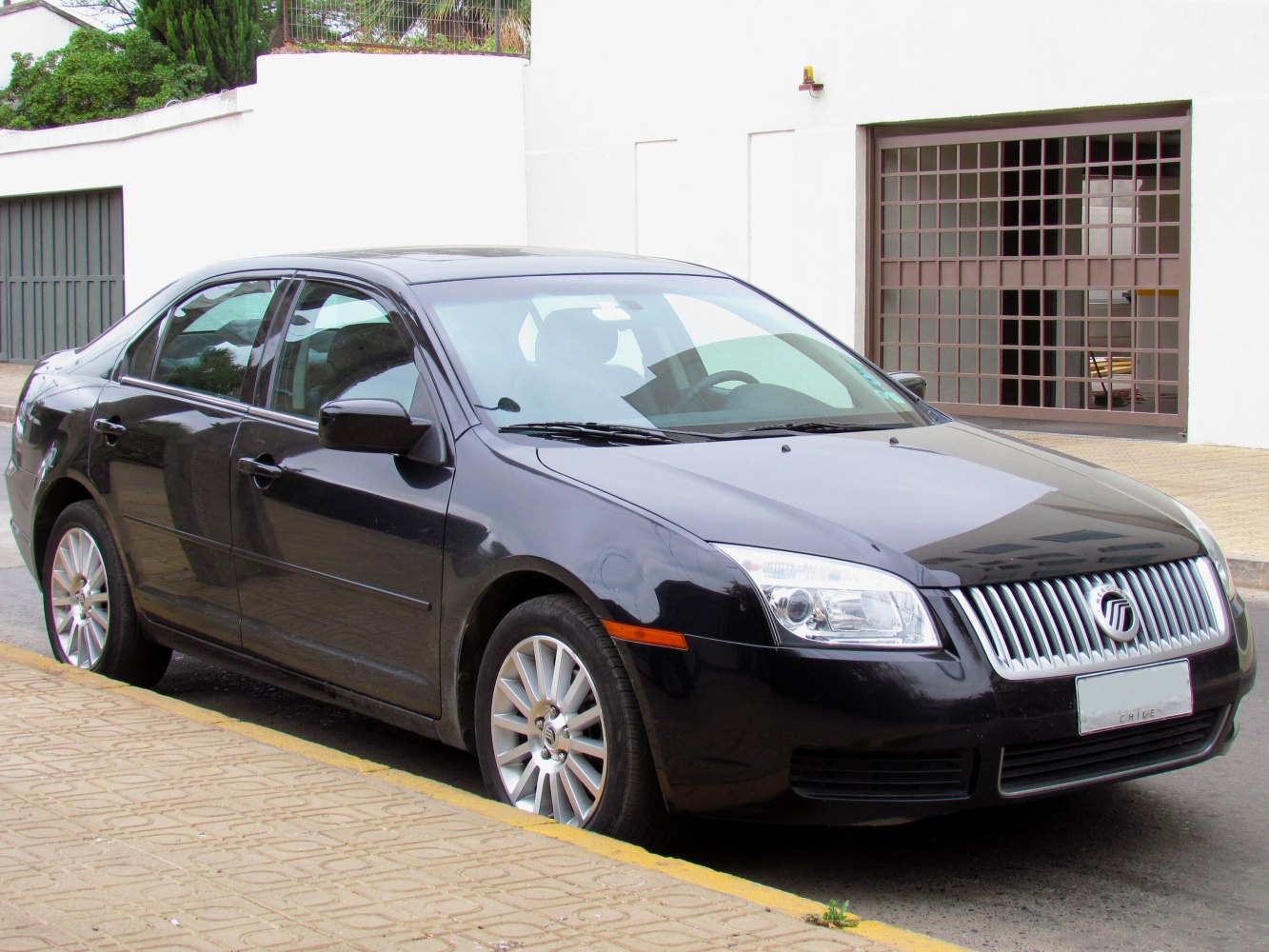 Front side view of sedan with chrome grille and alloy wheels