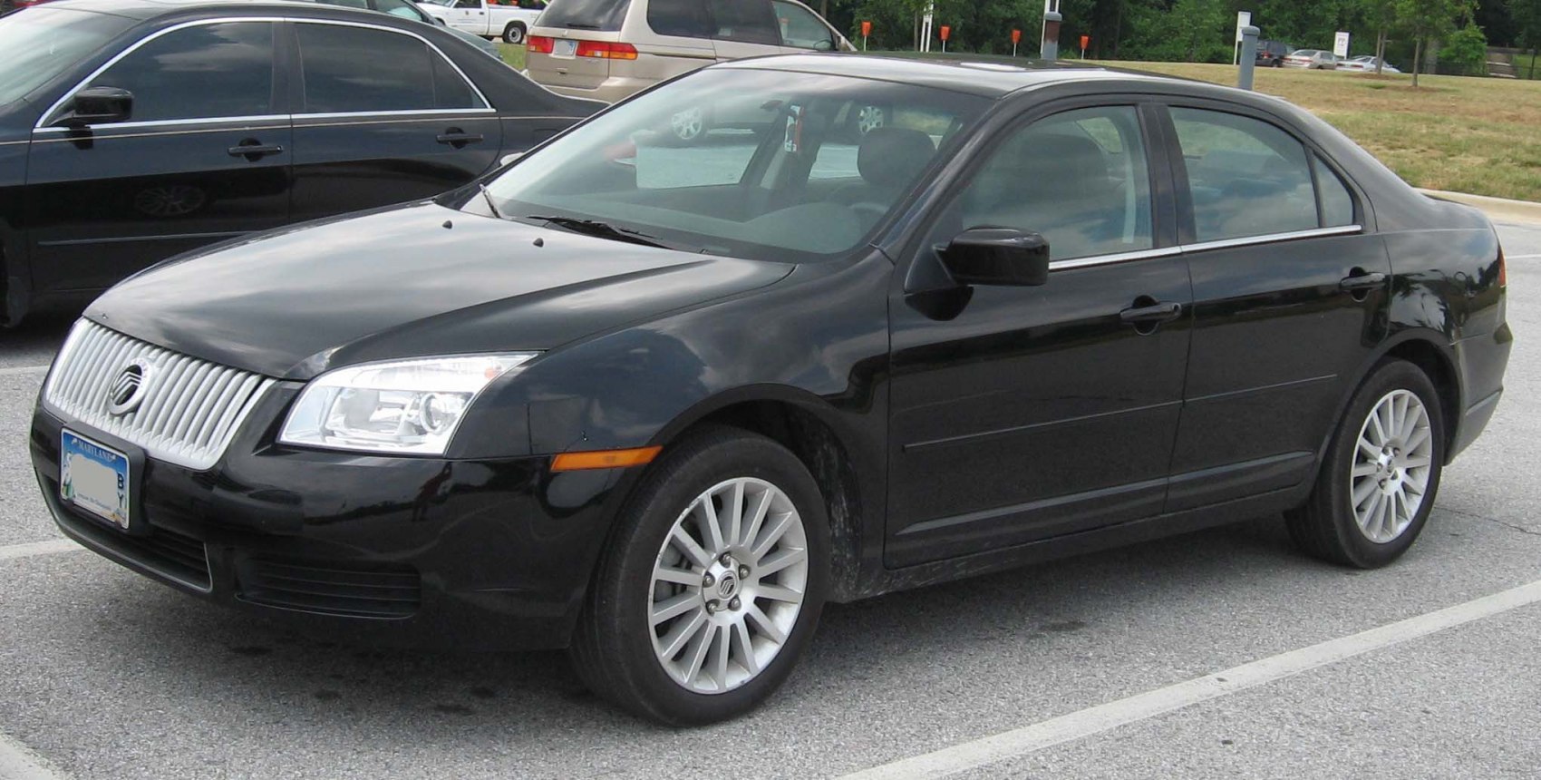 Black four-door sedan with vertical grille and alloy wheels