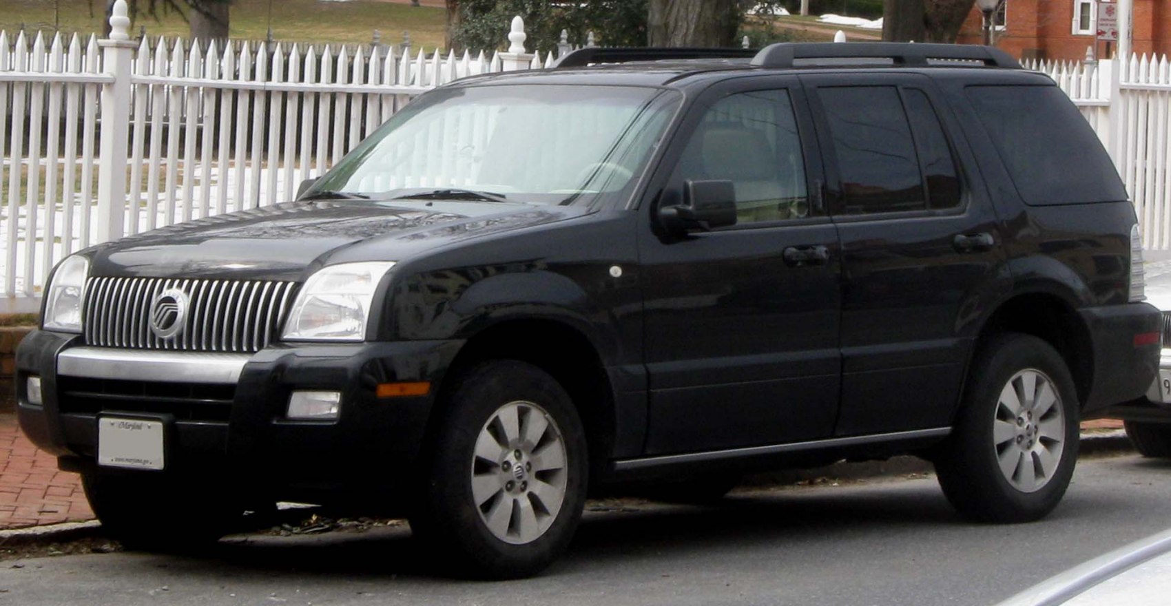 Black SUV with front grille and roof rails from side view