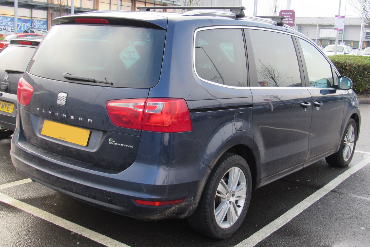 Rear side of blue multi-purpose vehicle with roof rails and Ecomotive badge