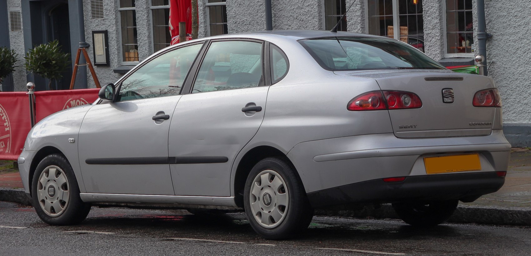 Silver sedan rear and side view with distinctive tail lights and compact design