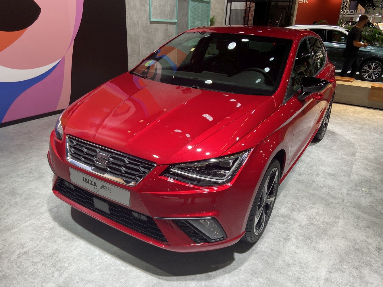 Sporty compact hatchback with sharp headlights and honeycomb grille.