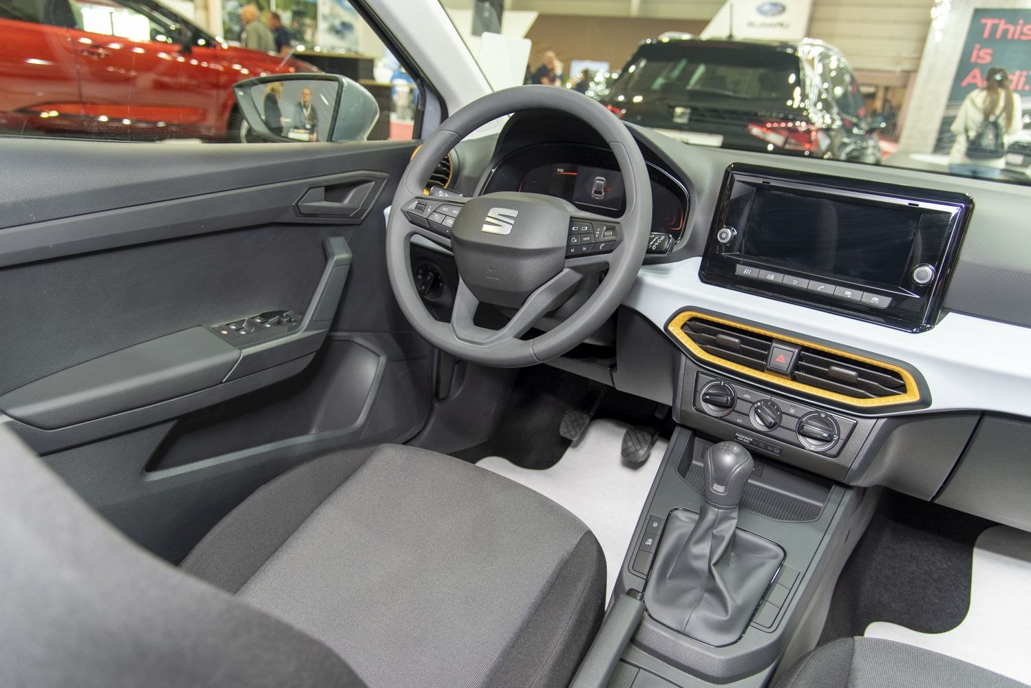 Multifunction steering wheel and modern center console with digital display and gear shift.