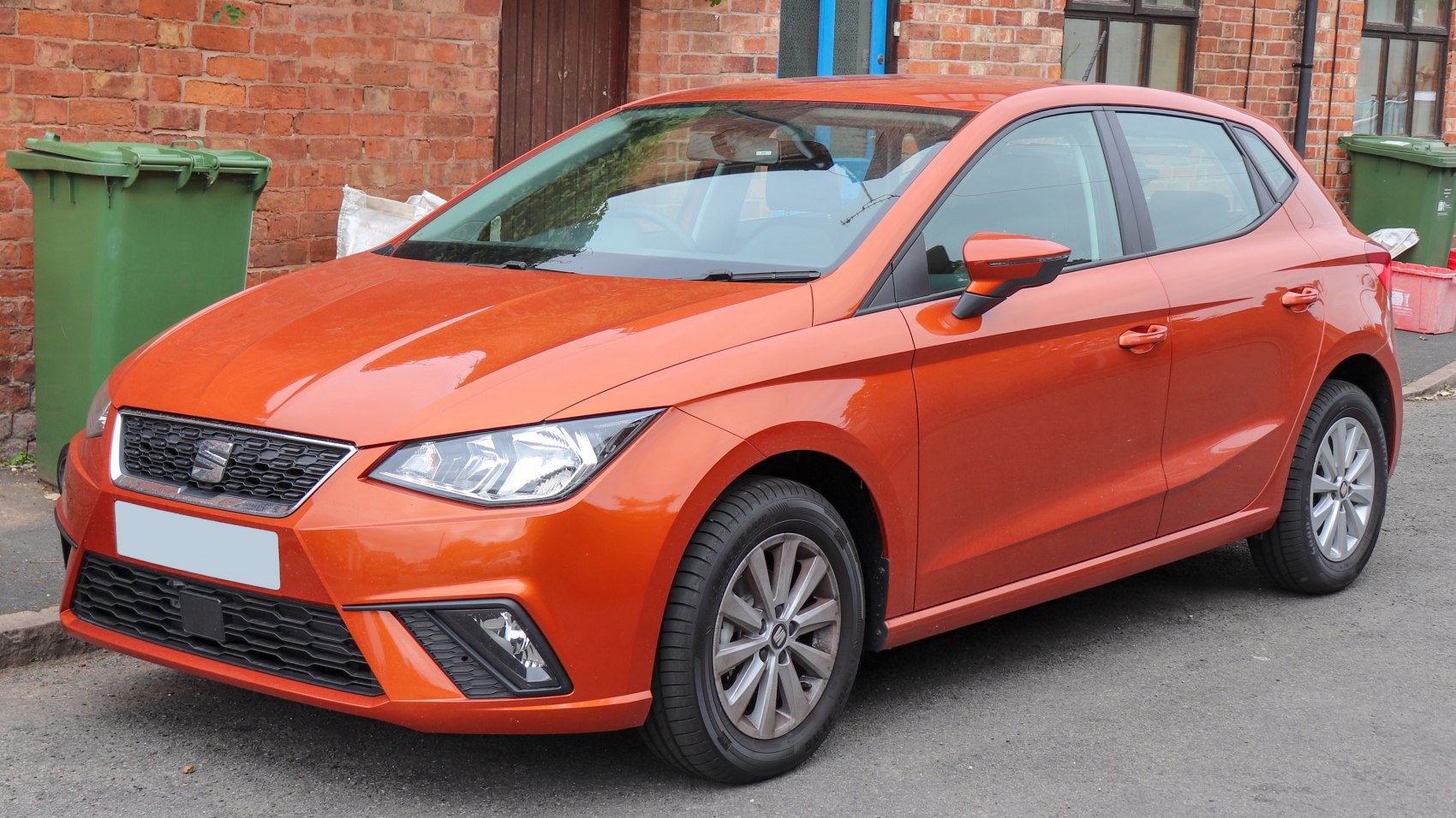 Compact orange hatchback front-side view with angular headlights