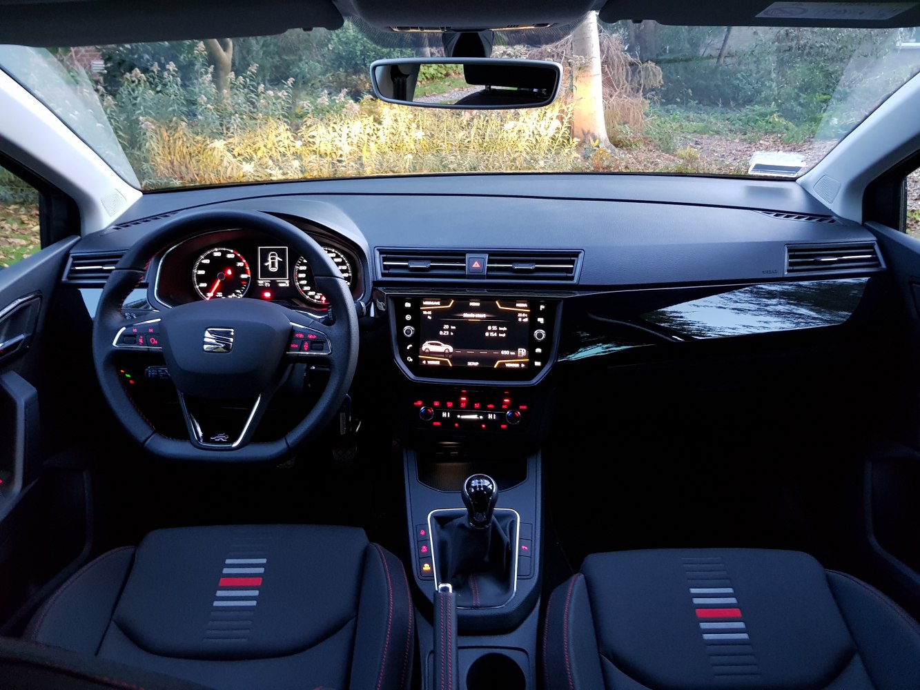 Interior view with dashboard, steering wheel, center console with manual gear shift