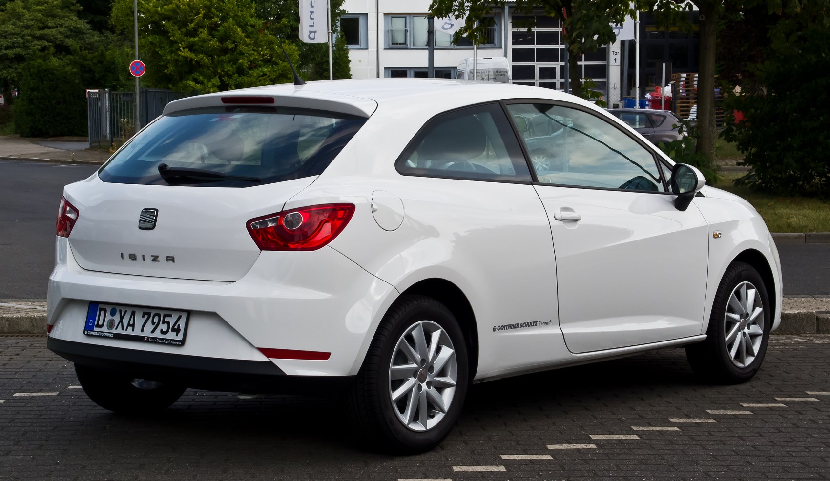 Rear and side profile of a white three-door hatchback with distinctive taillights and alloy wheels.