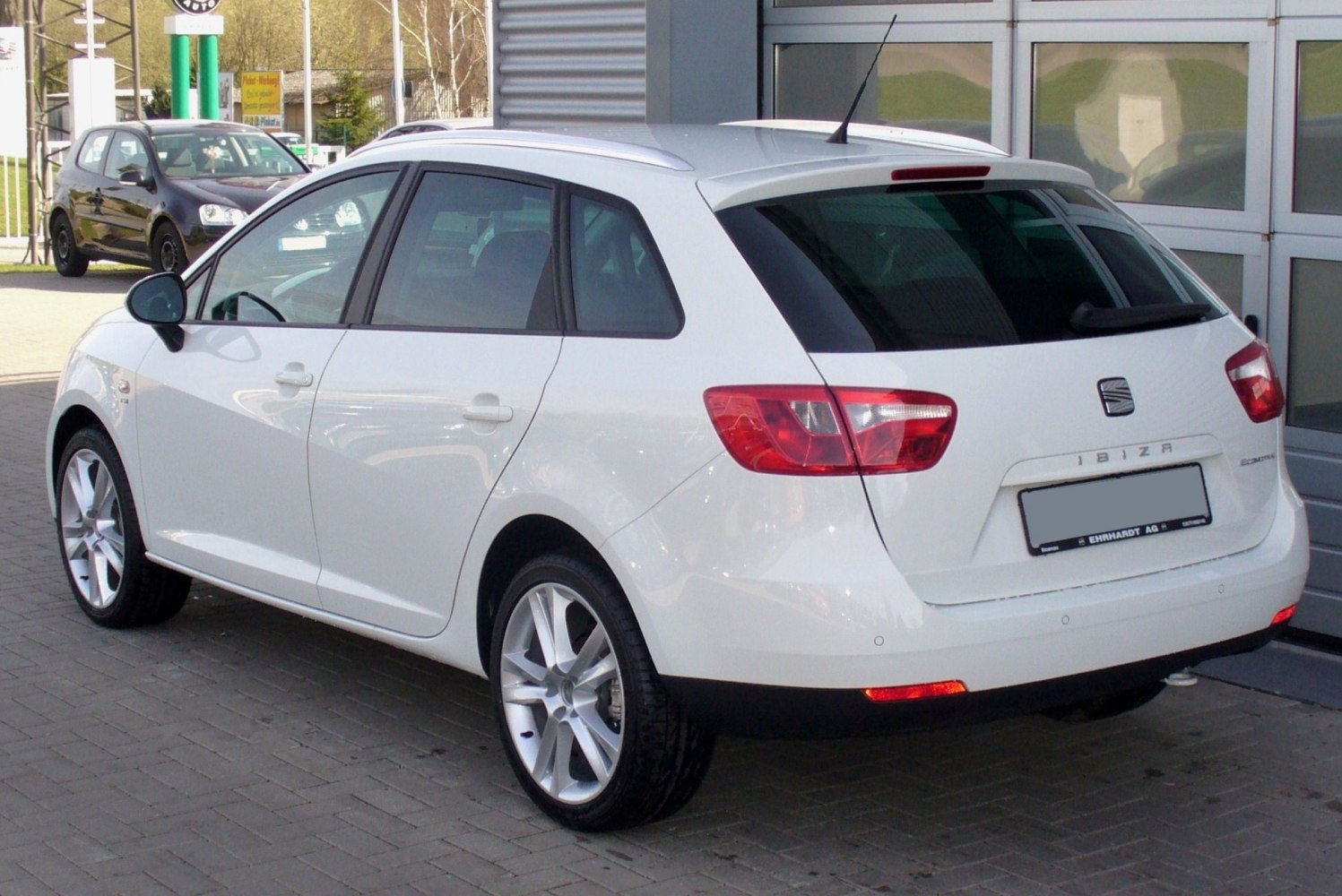 Rear view of white station wagon with distinctive tail lights and rear window
