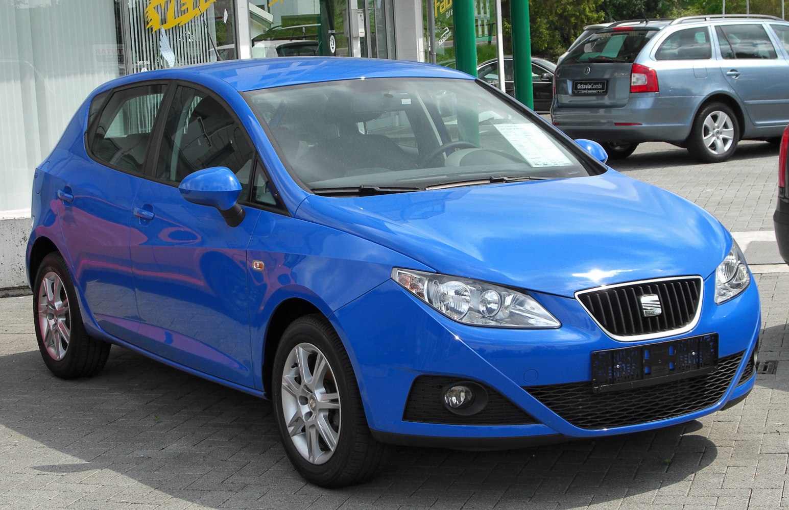 Blue compact hatchback with angular headlights and black grille front view