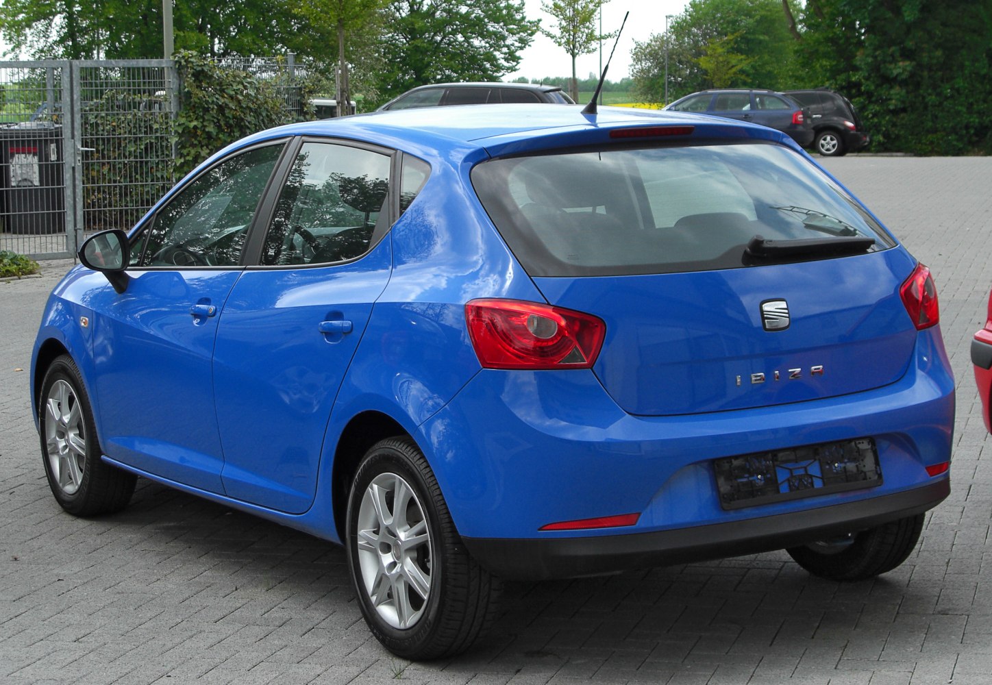 Rear view of blue hatchback with distinctive taillights and rear wiper