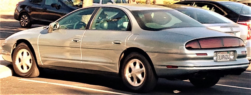 Smooth rounded rear sedan with alloy wheels in parking lot