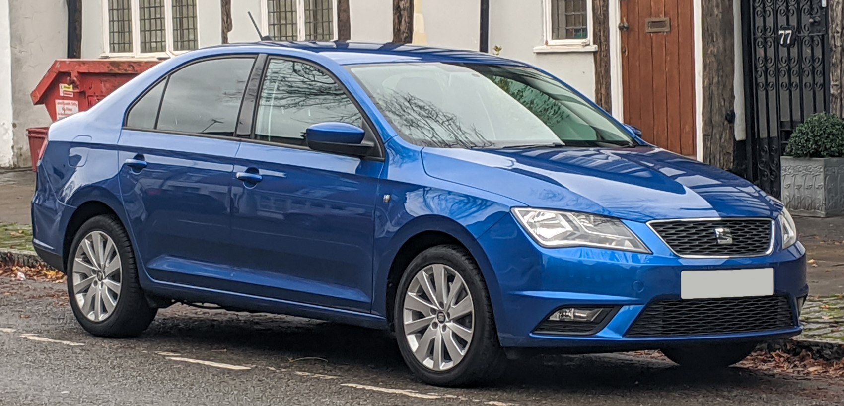 Blue sedan with alloy wheels and angular headlights.