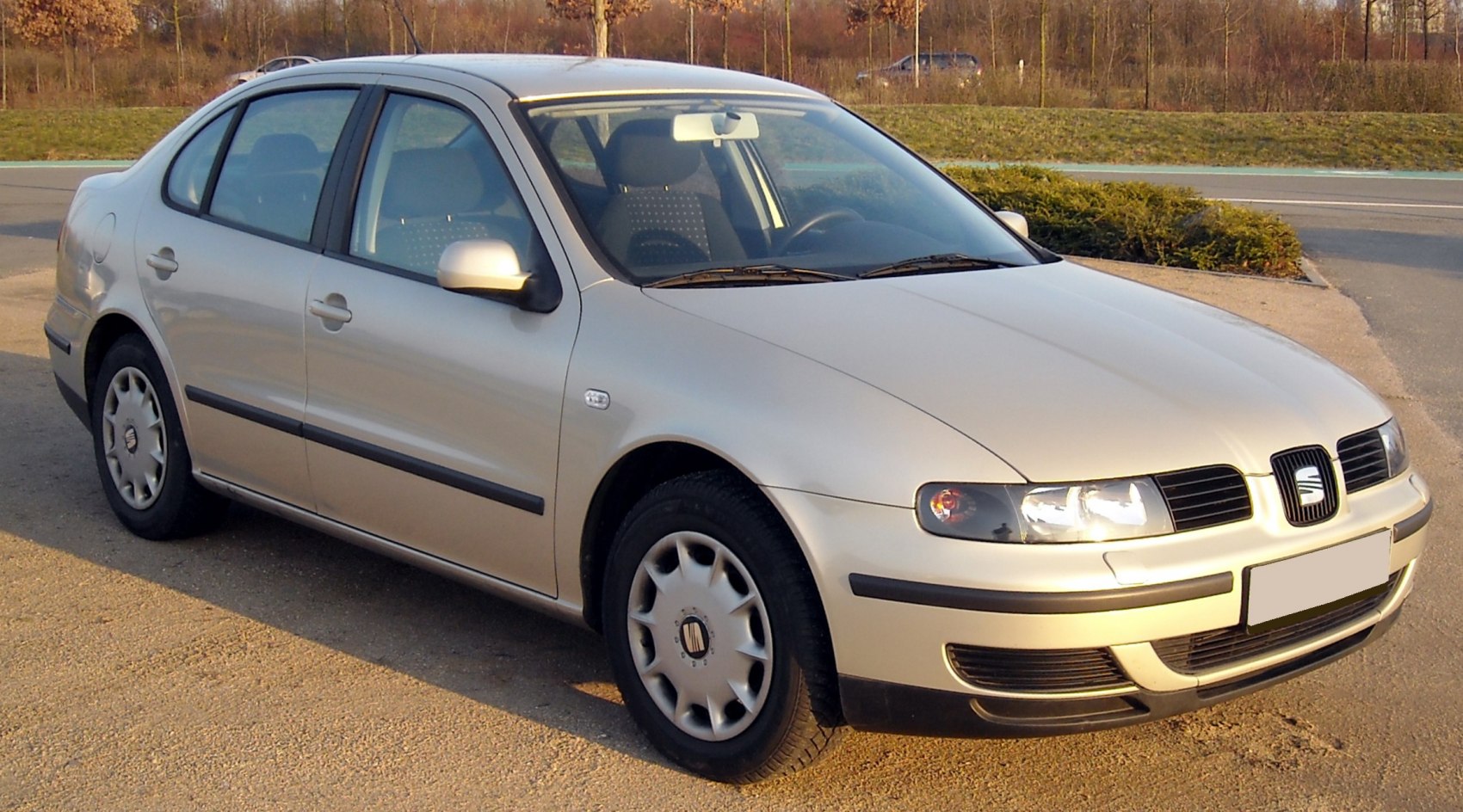 Front side view of compact 4-door sedan with rounded headlights