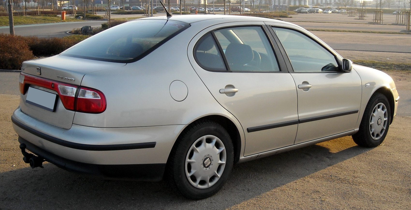 Rear side view of a silver four-door sedan with distinct tail lights and alloy wheels
