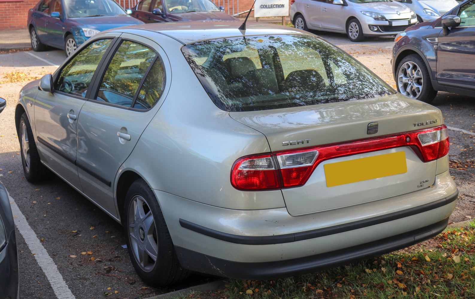 Rear view of a sedan with distinctive tail lights and side body panel in parking lot