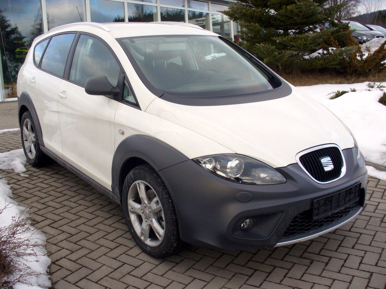 White compact crossover with black plastic bumpers and silver roof rails.